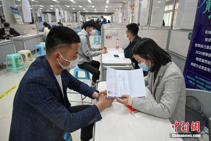 4月14日，招聘者在查看求職者簡歷。<a target='_blank'  data-cke-saved- >中新社</a>記者 王剛 攝