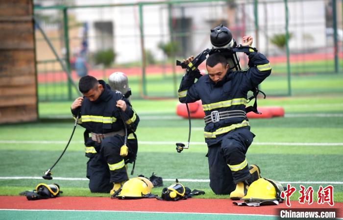 新消防員進(jìn)行穿戴空呼器展示?！⒅铱?攝