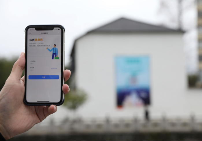 在浙江省杭州市臨安區(qū)天目山鎮(zhèn)，一名居民在“杭州健康碼”海報(bào)上掃碼申領(lǐng)個(gè)人二維碼。新華社發(fā)