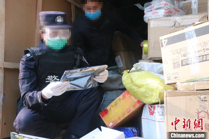 圖為勐康邊檢站民警在對(duì)快遞運(yùn)輸車輛進(jìn)行例行檢查。　楊添 攝