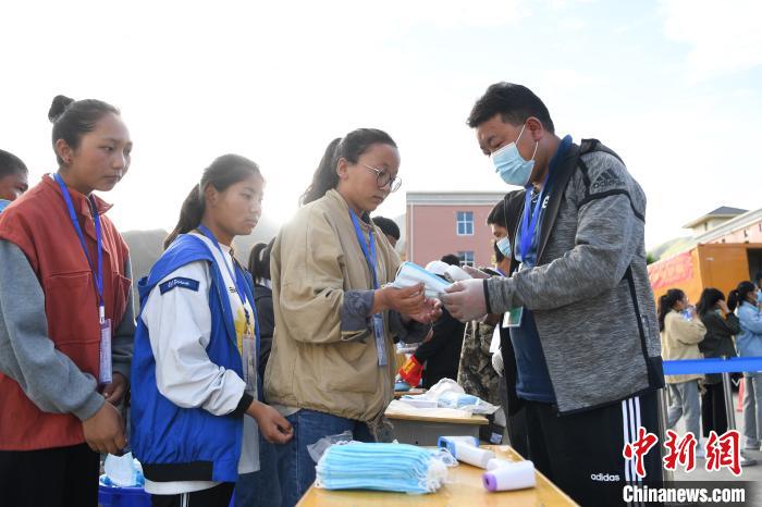 7月7日，考生在拉薩三高考點(diǎn)外領(lǐng)取口罩?！『闻罾?攝