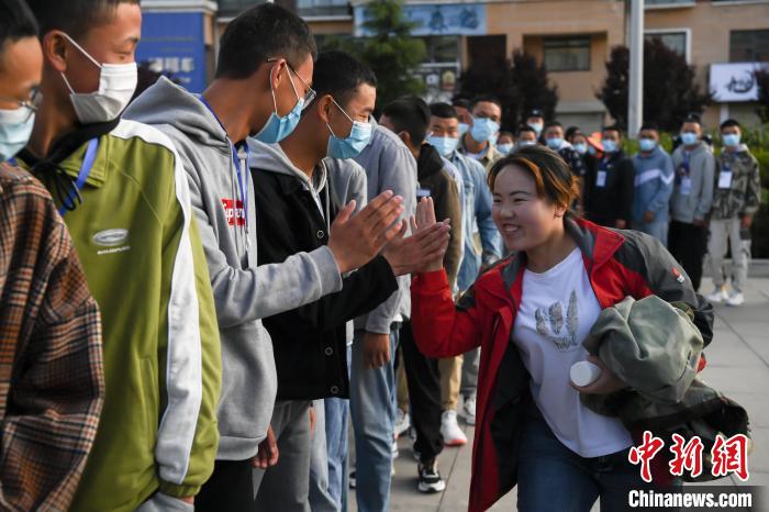 7月7日，拉薩三高考點(diǎn)外，領(lǐng)隊(duì)老師與考生擊掌鼓勁加油?！『闻罾?攝