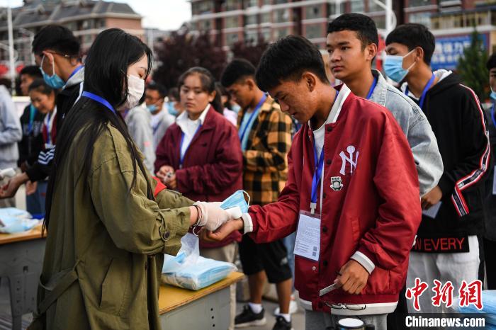 7月7日，考生在拉薩三高考點(diǎn)外測(cè)量體溫?！『闻罾?攝