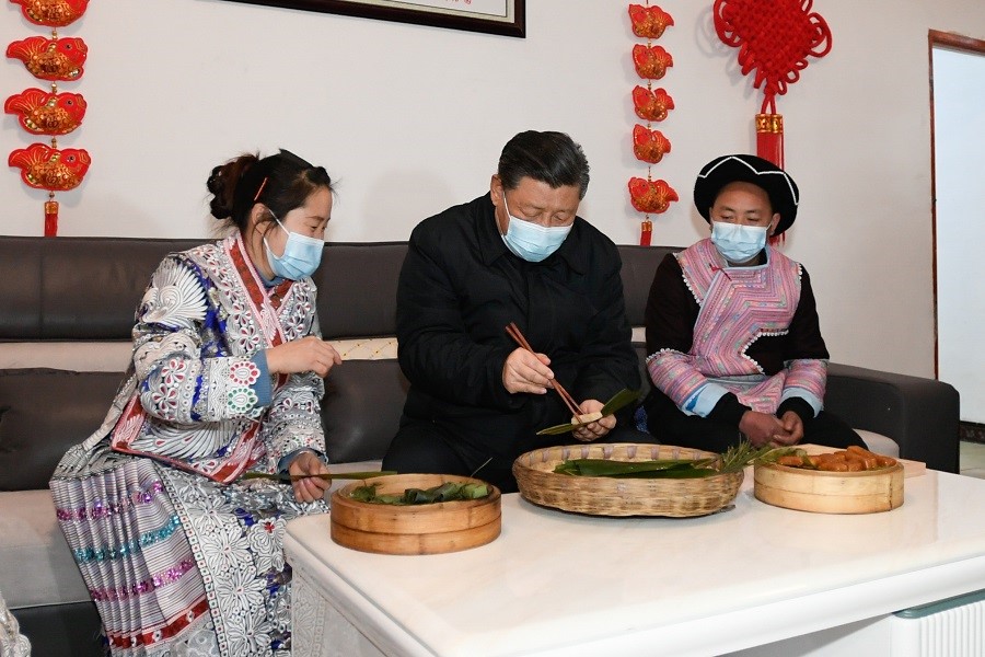 2021年2月3日下午，習(xí)近平在貴州畢節(jié)市黔西縣新仁苗族鄉(xiāng)化屋村苗族村民趙玉學(xué)家，同一家人邊聊家常邊制作當(dāng)?shù)貍鹘y(tǒng)節(jié)日食品黃粑。新華社記者 李學(xué)仁 攝